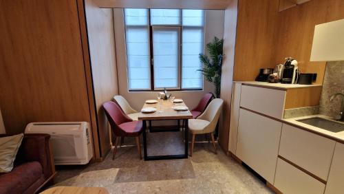 een kleine keuken met een tafel met stoelen en een raam bij FS Apartments - Wonderful apartment in the top center of Varna in Varna