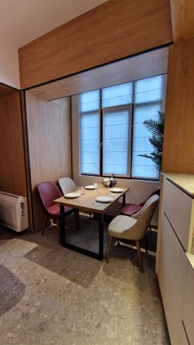 een eetkamer met een tafel, stoelen en ramen bij FS Apartments - Wonderful apartment in the top center of Varna in Varna