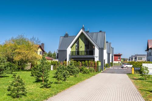 a house with a gray roof and a driveway at Žalia kopa in Palanga