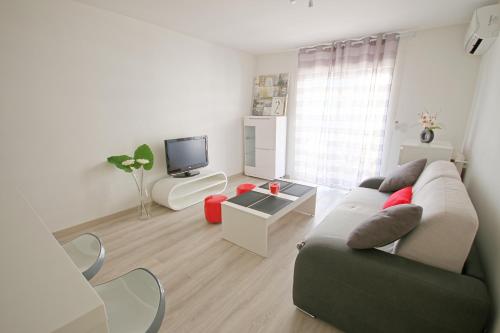 un salon avec un canapé et une télévision dans l'établissement Résidence Gambetta, à Antibes