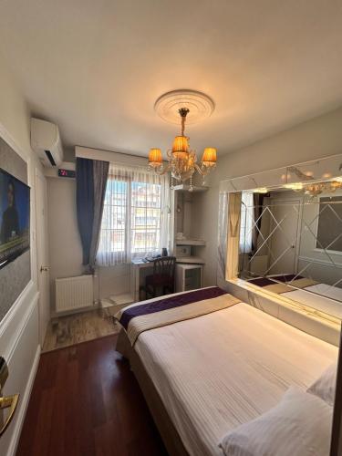 um quarto com uma cama grande e um lustre em Bakirkoy Tashan Business & Airport Hotel em Istambul