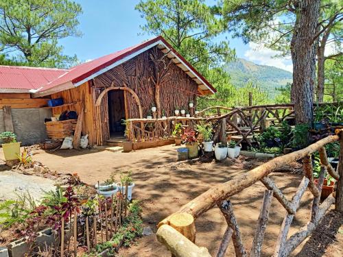 una cabaña de madera con una valla delante en IYAMAN FARM NEAR SAGADA MOUNTAIN PROVINCE, PH, 