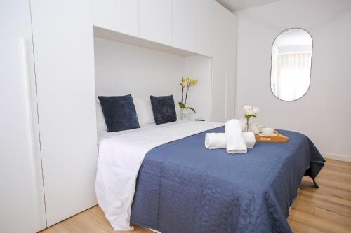 um quarto com uma cama grande e um cobertor azul em AL39 - Atico con barbacoa playa Fenals em Lloret de Mar