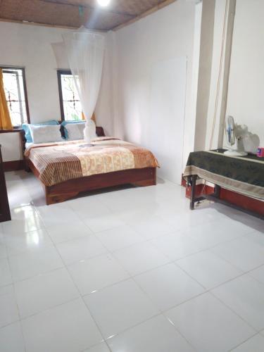 a bedroom with a bed and a sink in it at Kembang Kuning Cottages in Tetebatu