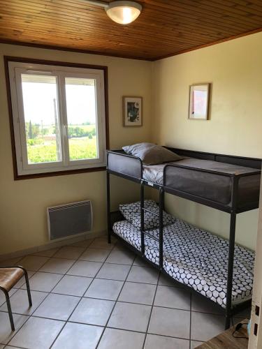 deux lits superposés dans une chambre avec fenêtre dans l'établissement Le Petit Gîte de Javernières Etage, à Villié-Morgon