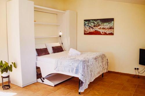 een slaapkamer met een wit bed en een tv bij Quinta da Bela Vista in Lagos