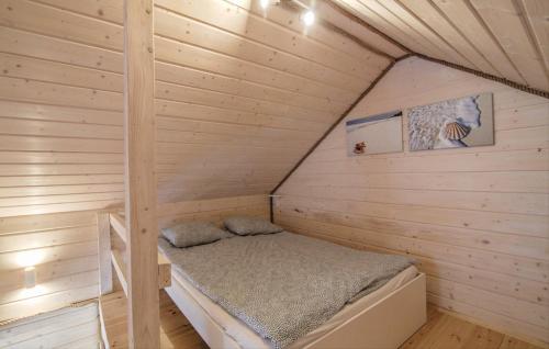Czarny MłynにあるOstoja Sosnowa Czarny Mlyn, kompleks dwóch nowych domkowの木造キャビン内のベッド1台が備わる小さな客室です。