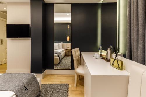 a room with a bed and a desk with a mirror at Hotel Amira Istanbul in Istanbul