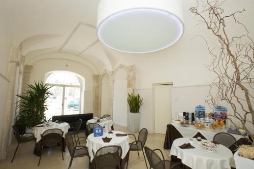 un comedor con mesas y sillas y una gran lámpara de araña en Villa Fornari Resort, en Bisceglie