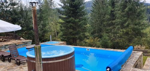 a jacuzzi tub with a view of the mountains at L - Hutir in Mykulychyn