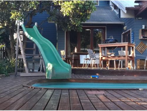 a green slide on a deck next to a pool at Knysna Holiday Armadillo in Knysna