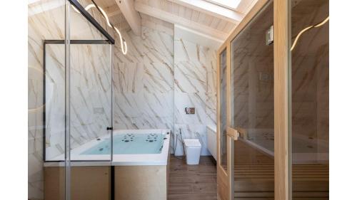 a bathroom with a tub and a glass shower at Salina SPA Villas - with PRIVATE HEATED ECO-POOL, SAUNA & JACCUZI HOT TUB in Volos