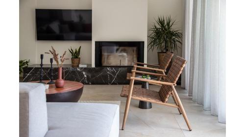 a living room with a chair and a table at Salina SPA Villas - with PRIVATE HEATED ECO-POOL, SAUNA & JACCUZI HOT TUB in Volos