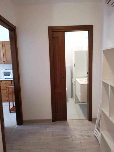 una puerta abierta a una cocina con nevera en Bluelake Apartment 3 Omegna en Omegna