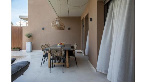 a dining room with a table and chairs at Salina SPA Villas - with PRIVATE HEATED ECO-POOL, SAUNA & JACCUZI HOT TUB in Volos