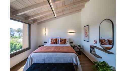 a bedroom with a large bed and a large window at Salina SPA Villas - with PRIVATE HEATED ECO-POOL, SAUNA & JACCUZI HOT TUB in Volos