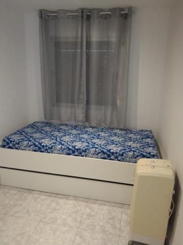 a small bedroom with a bed and a window at piso pilar in Chiclana de la Frontera
