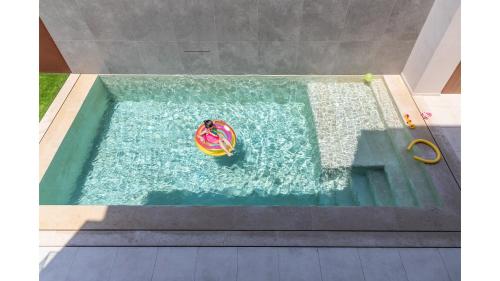 an overhead view of a pool with a toy in the water at Salina SPA Villas - with PRIVATE HEATED ECO-POOL, SAUNA & JACCUZI HOT TUB in Volos