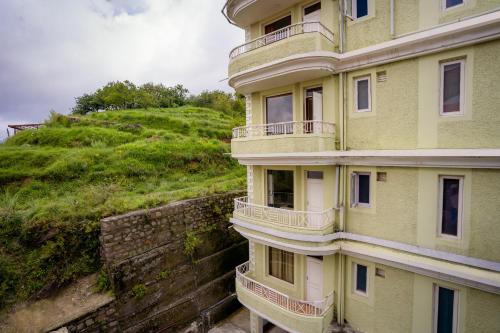 a building on the side of a hill at Hostie Mystica - 3BHK luxury apartment, Mashobra, Shimla in Shimla
