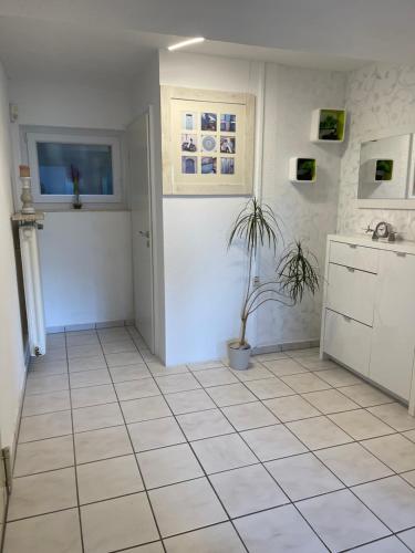 a kitchen with white tile floors and a potted plant at Albblick in Albstadt