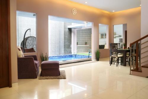 a living room with a swimming pool in a house at Rumah Teteh - Plemburan in Kejayan