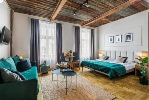 Habitación de hotel con cama y sofá en Aparthotel Pergamin, en Cracovia