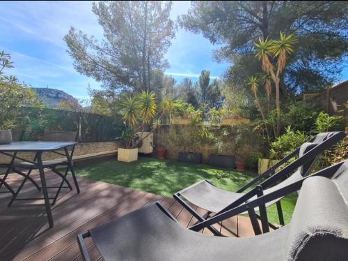 un patio avec une table et des chaises dans une cour dans l'établissement Jardin Privé ds le Centre de Cassis - Parking - Plage à 500m, à Cassis