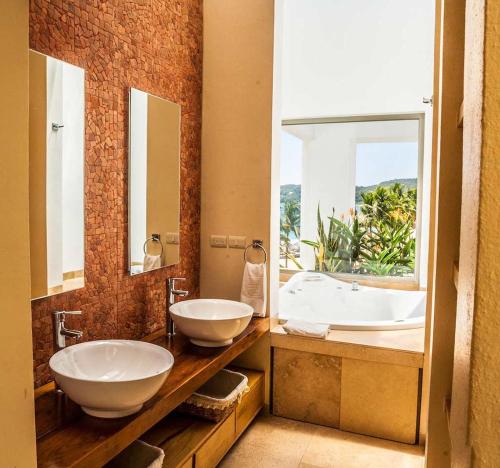 a bathroom with two sinks and a large window at 2029 - Villa Camino Real in Santa Cruz Huatulco