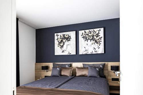 ein Schlafzimmer mit einem Bett mit zwei Bildern an der Wand in der Unterkunft Villa Infinity - Luxurious seaview Villa with enchanting Pool in Kali