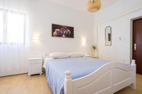 a white bedroom with a white bed and a window at Dubasa B&B in Vantačići