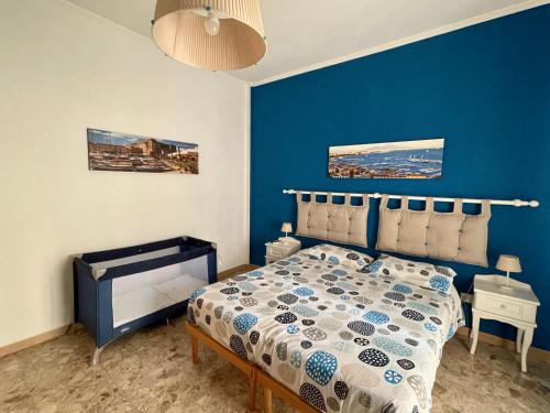 niebieska sypialnia z łóżkiem i niebieską ścianą w obiekcie Il Canto di Partenope w mieście Napoli