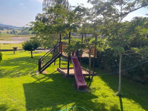 a playground in a yard with a slide at Cantabria Collection - Espectacular casa con piscina y jardín in Oruña