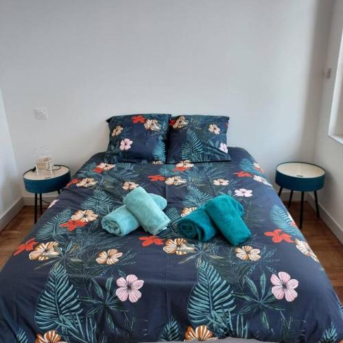 a bed with blue comforter and two pillows on it at Appartemement F2 refait à neuf hyper centre in Coutances