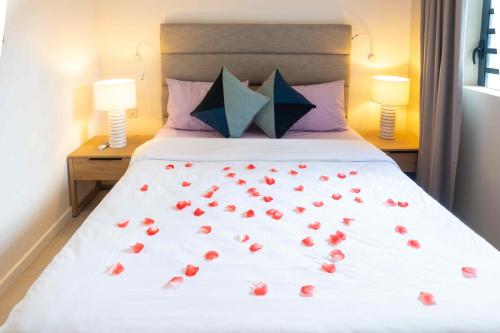 a bed with red roses on it with two lamps at Nautilya with LOV in Pointe aux Cannoniers