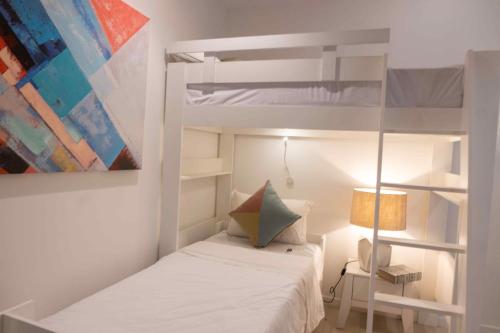 a small bedroom with a bunk bed and a lamp at Nautilya with LOV in Pointe aux Cannoniers