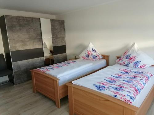 two beds in a small room with flowers at Ferienwohnung Valentin in Baustert