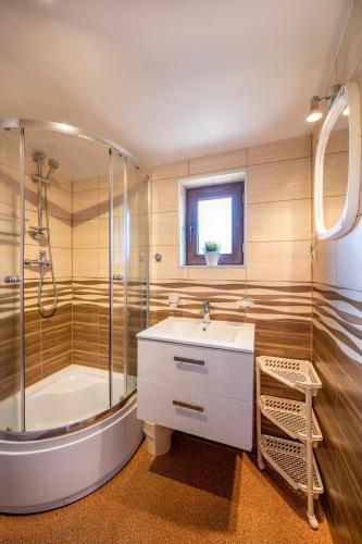 a bathroom with a tub and a sink and a shower at Uroczy Zakatek in Chłopy