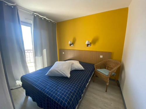 - une chambre avec un lit bleu et un mur jaune dans l'établissement VUE MER 4 pers. 50 m plage Clim Piscine Parking HH FERNANDE, à Cannes