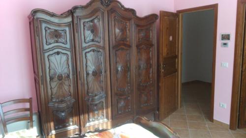 a large wooden cabinet in the corner of a room at il Balcone sul Monferrato in Tonco