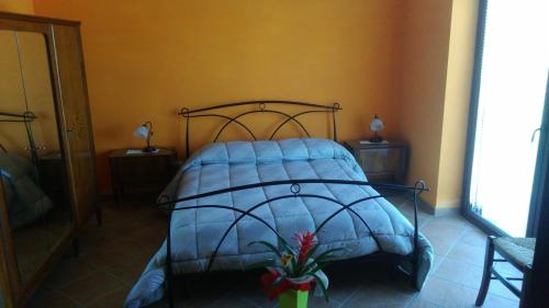 a bed with a blue comforter in a bedroom at il Balcone sul Monferrato in Tonco