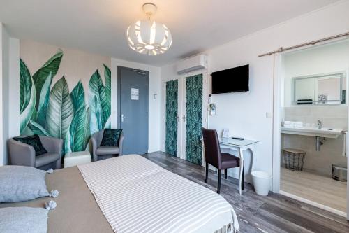 a hotel room with a bed and a desk and chairs at Villa Cordouan in Saint-Palais-sur-Mer