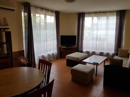 a living room with a table and a tv at Guest Rooms Flirt in Golden Sands