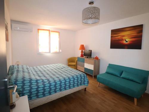 a bedroom with a bed and a green chair at Beau 3 pièces climatisé, piscine privée, parking au Grau-du-Roi - FR-1-307-215 in Le Grau-du-Roi