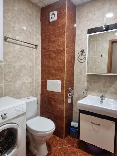 uma casa de banho com um WC, um lavatório e uma máquina de lavar roupa em Apartment Prestige Fort Beach, Studio em Sveti Vlas