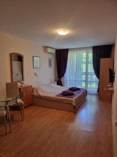 um quarto com uma cama, uma mesa e um espelho em Apartment Prestige Fort Beach, Studio em Sveti Vlas
