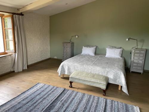 a bedroom with a bed and a ottoman in it at Le Chai de Marguerite in Peyriac-Minervois