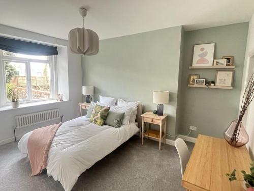 a bedroom with a bed and a table and a window at Restful Victorian Apartment with Garden in Bristol