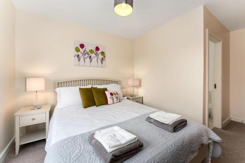 a bedroom with a white bed with two tables and two lamps at Apartment 144 - Clifden in Clifden