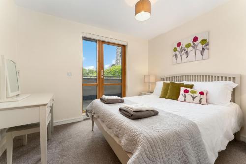 a white bedroom with a bed and a desk at Apartment 144 - Clifden in Clifden