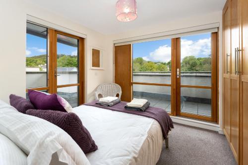 a bedroom with two beds and a balcony at Apartment 144 - Clifden in Clifden